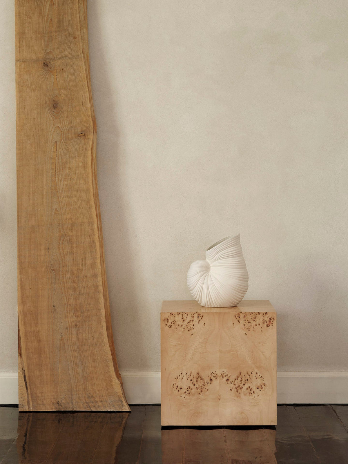 Vase Shell blanc cassé sans fleurs sur un socle en bois.