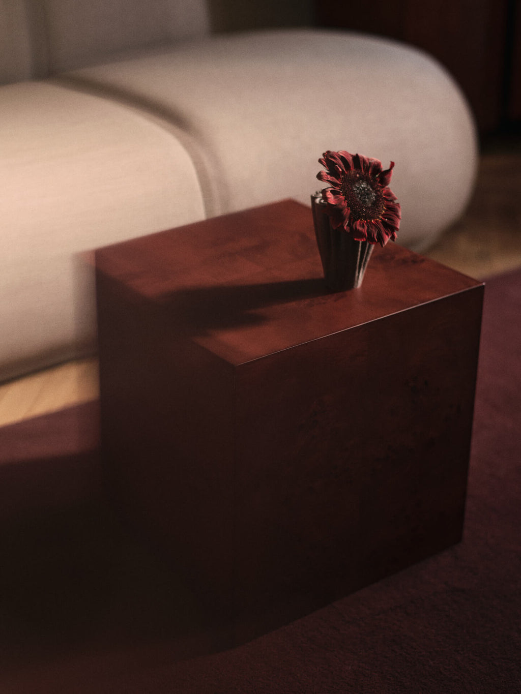 Petit vase Dedali brun foncé avec une fleur sur une table d’appoint.